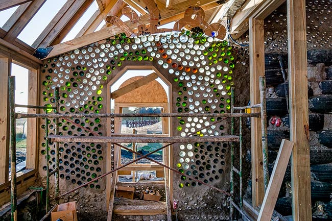 pared de botellas de vidrio y latas recicladas