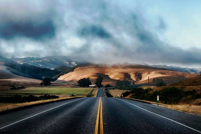 estratocumulos sobre montañas y carretera