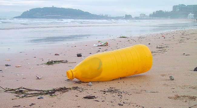 botella de plástico abandonada en playa 